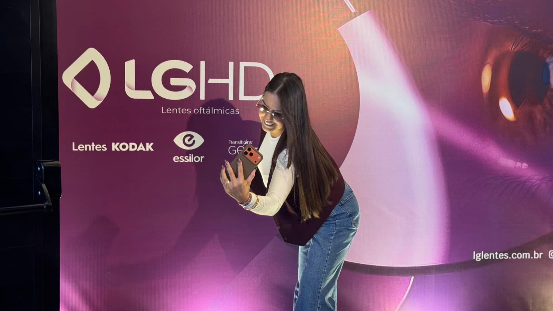 Convidada diante do painel da nova marca, com Kodak, Essilor e Transitions Gen S